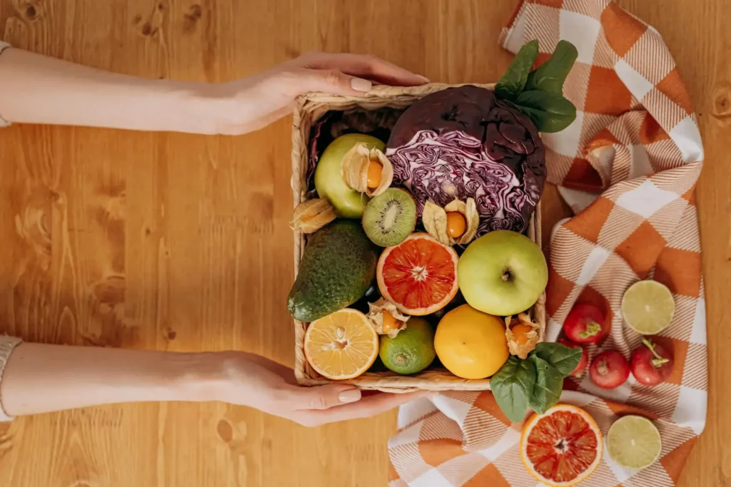 A person holding a basket of fruits